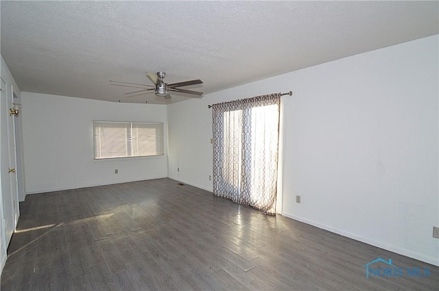 unfurnished room with ceiling fan, dark wood-type flooring, and a textured ceiling