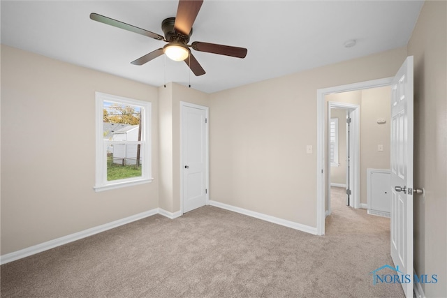 unfurnished bedroom featuring light carpet and ceiling fan