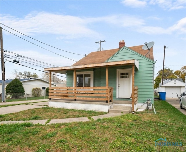 bungalow-style home with covered porch and a front yard