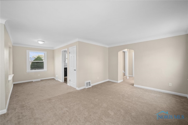 empty room with light carpet and crown molding