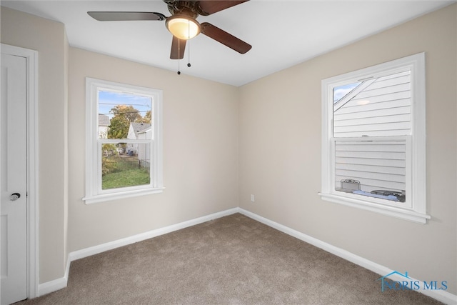 carpeted spare room with ceiling fan