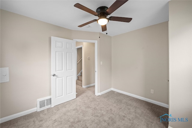 spare room featuring ceiling fan and light carpet