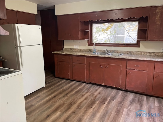 kitchen with dark hardwood / wood-style flooring, white appliances, and sink