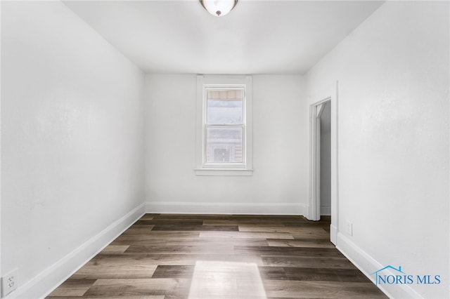 spare room with dark wood-type flooring