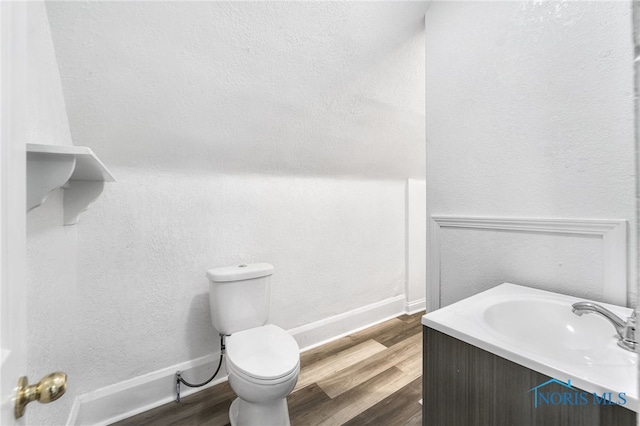 bathroom with hardwood / wood-style flooring, vanity, and toilet