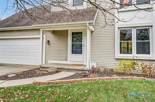 property entrance featuring a garage and a yard