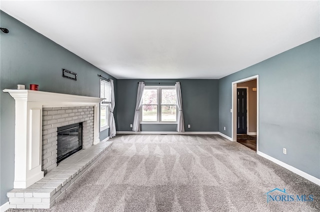 unfurnished living room with a brick fireplace and carpet flooring