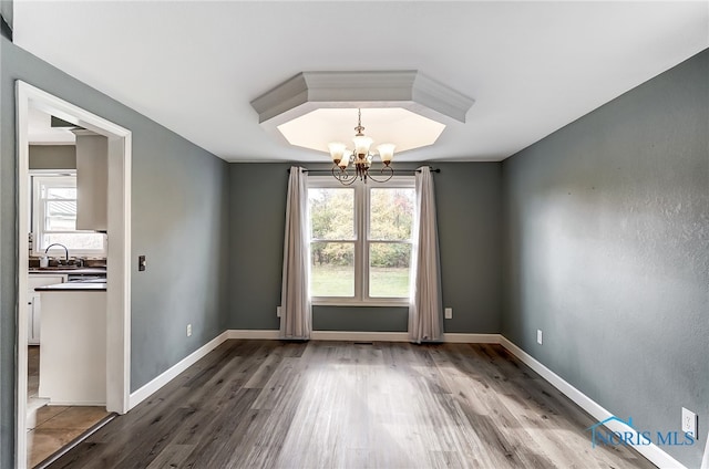 empty room featuring a notable chandelier, hardwood / wood-style flooring, and sink