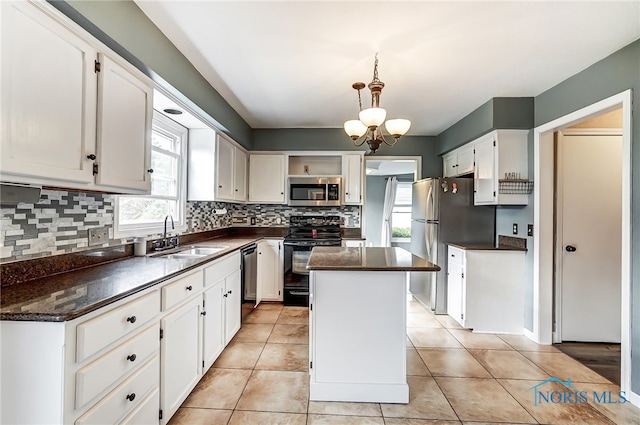 kitchen featuring appliances with stainless steel finishes, sink, a healthy amount of sunlight, and a center island