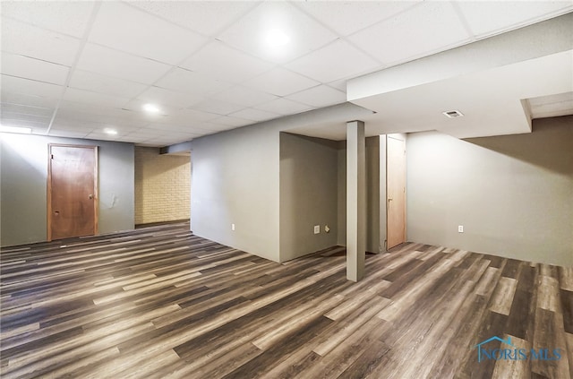 basement featuring dark hardwood / wood-style flooring and a drop ceiling