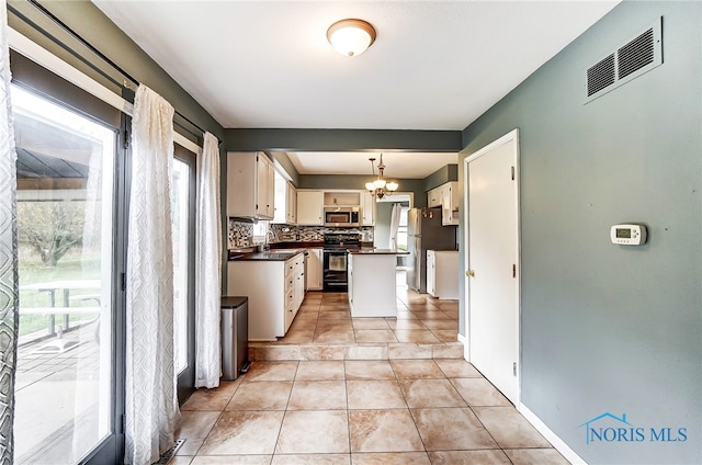 kitchen featuring stainless steel appliances, plenty of natural light, and hanging light fixtures