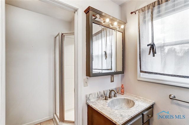 bathroom featuring an enclosed shower, plenty of natural light, and vanity