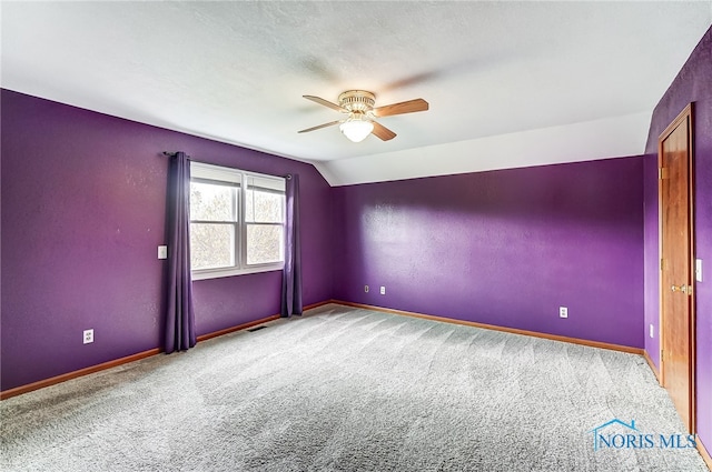 carpeted empty room with lofted ceiling and ceiling fan