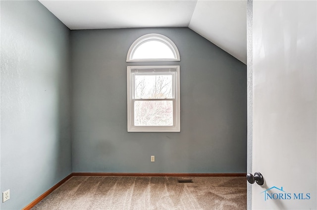 unfurnished room with vaulted ceiling and carpet flooring