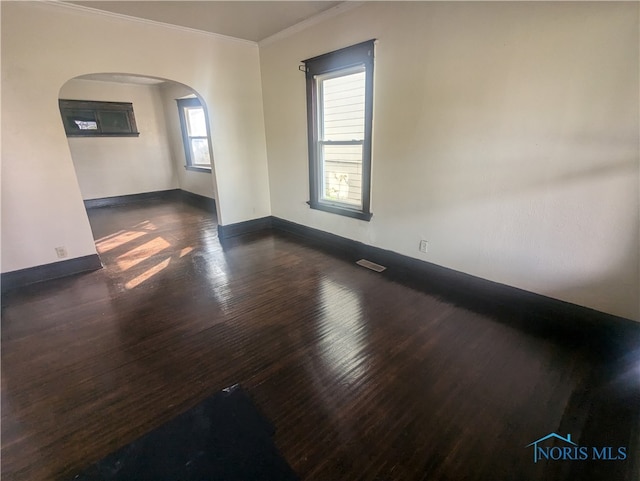 spare room with dark wood-type flooring and crown molding