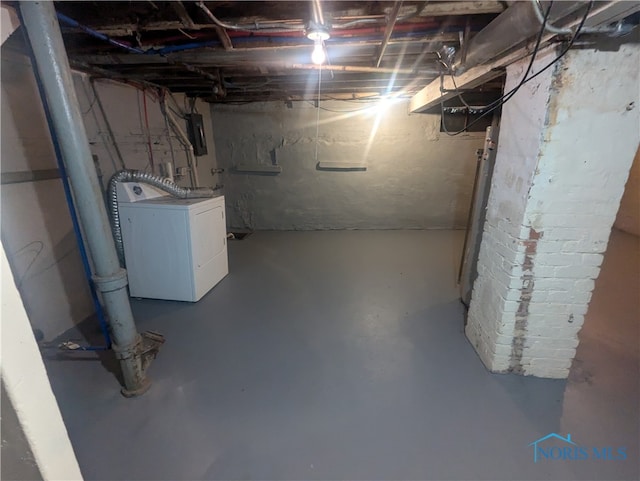 basement featuring electric panel and washer / dryer