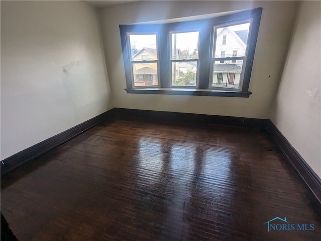 empty room with dark hardwood / wood-style flooring