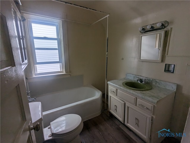 full bathroom with toilet, washtub / shower combination, vanity, and hardwood / wood-style flooring