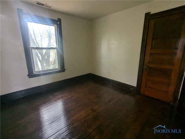 spare room featuring dark wood-type flooring