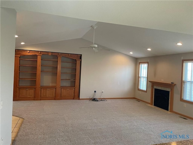 unfurnished living room with light colored carpet, a wealth of natural light, and lofted ceiling