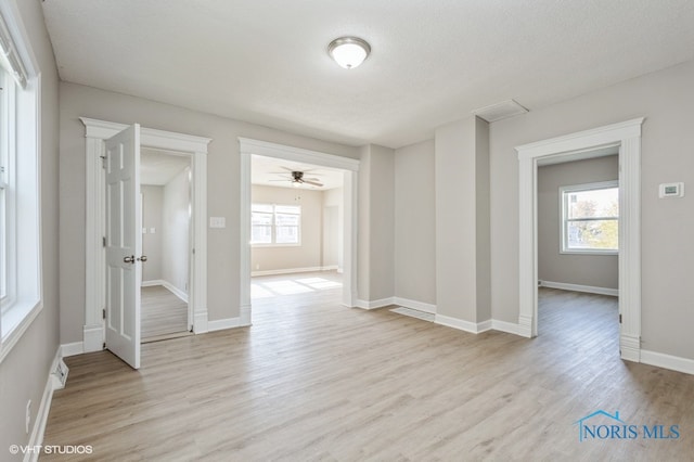 empty room featuring ceiling fan, a textured ceiling, and light wood-type flooring