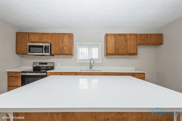 kitchen featuring appliances with stainless steel finishes, sink, and a textured ceiling