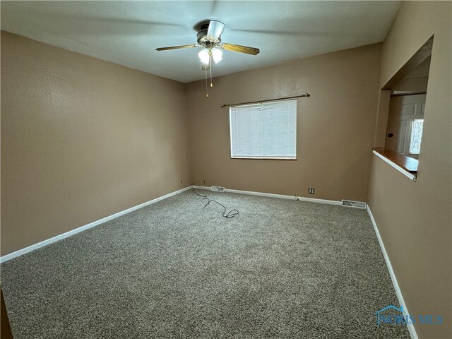 unfurnished room featuring ceiling fan and carpet