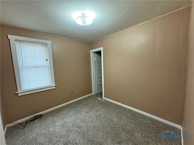 unfurnished room with a textured ceiling and carpet floors