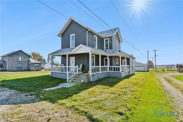 view of front facade featuring a garage, a front lawn, an outdoor structure, and a porch