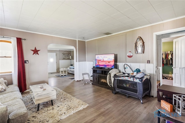 living room featuring ornamental molding and wood-type flooring