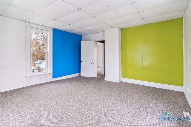 carpeted empty room featuring a paneled ceiling