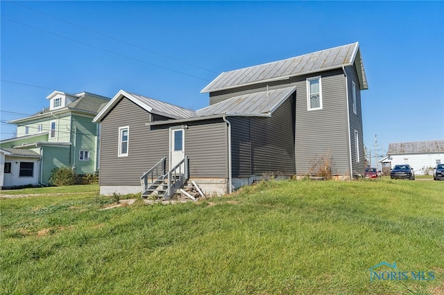 back of house with a lawn