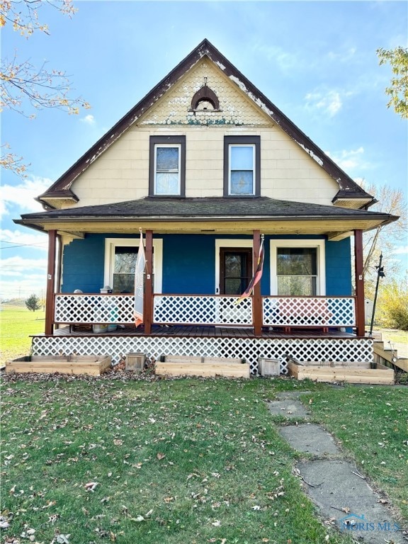 view of home's exterior with covered porch and a lawn