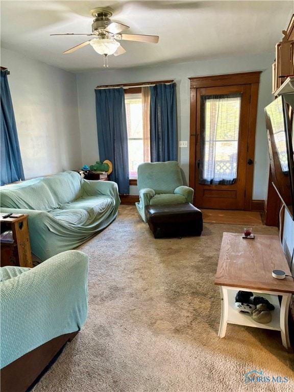 carpeted living room with ceiling fan