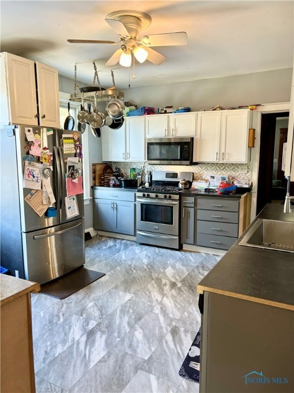 kitchen with white cabinets, decorative backsplash, ceiling fan, and appliances with stainless steel finishes