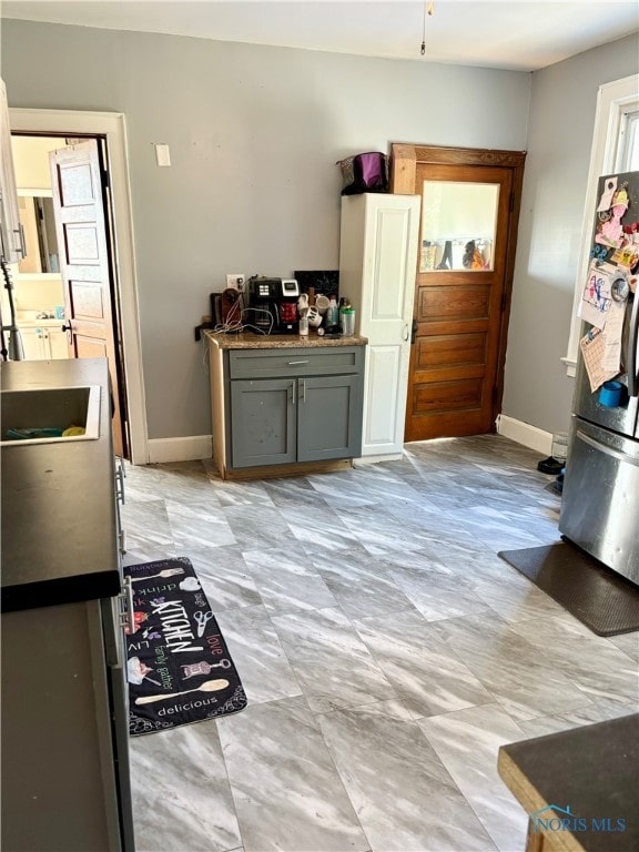 interior space with stainless steel fridge and gray cabinetry