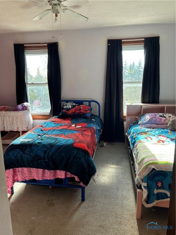 bedroom with carpet, ceiling fan, and a textured ceiling