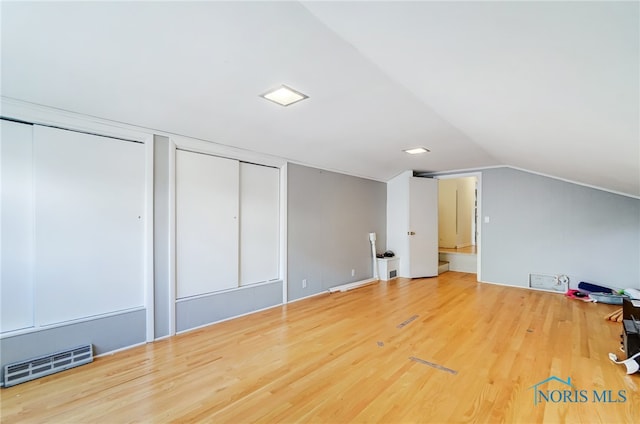 bonus room with hardwood / wood-style flooring and vaulted ceiling