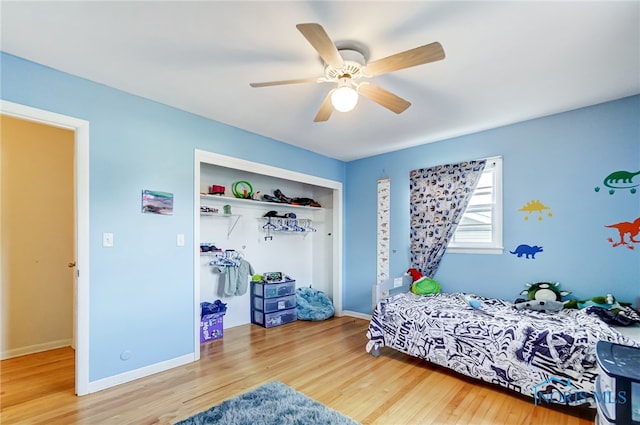 bedroom with wood-type flooring, ceiling fan, and a closet