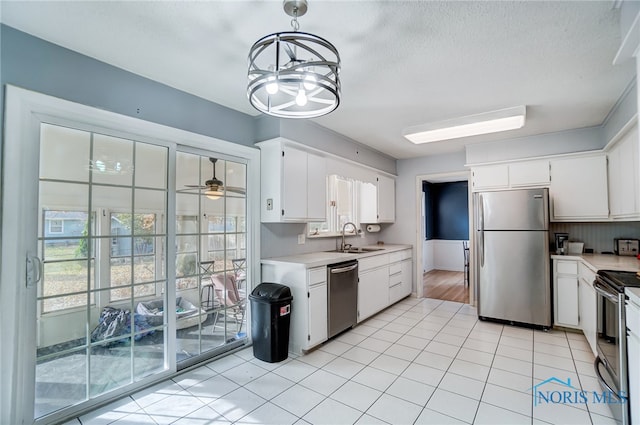 kitchen featuring white cabinetry, appliances with stainless steel finishes, decorative light fixtures, sink, and ceiling fan