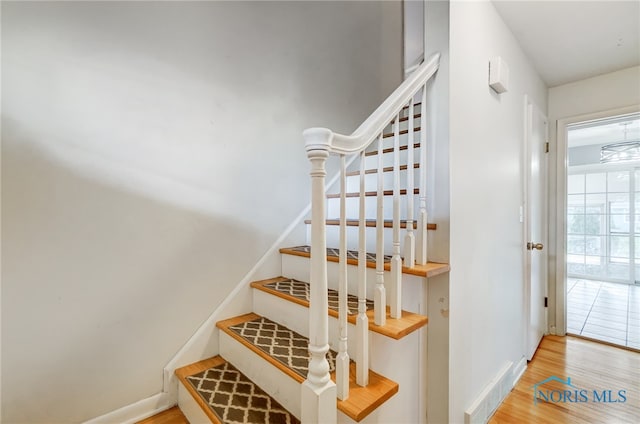 stairs with hardwood / wood-style floors