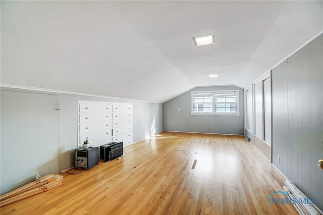 bonus room with light wood-type flooring and lofted ceiling