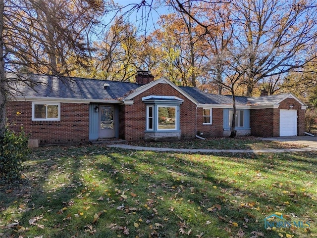 ranch-style home featuring a garage and a front lawn