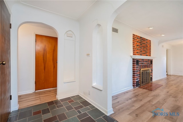 interior space with a brick fireplace and dark wood-type flooring