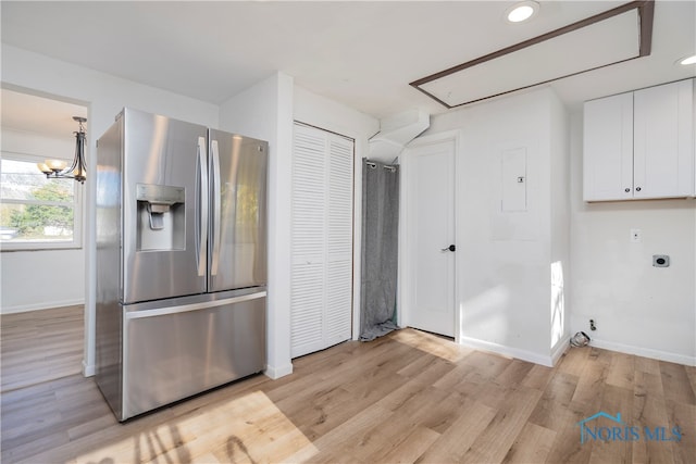 kitchen with stainless steel fridge with ice dispenser, white cabinetry, and light wood-type flooring