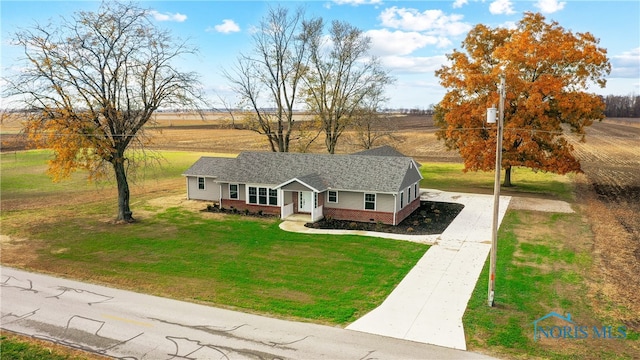 ranch-style home with a porch, a rural view, and a front yard