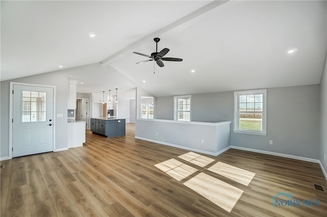 unfurnished living room featuring ceiling fan, lofted ceiling with beams, and hardwood / wood-style flooring