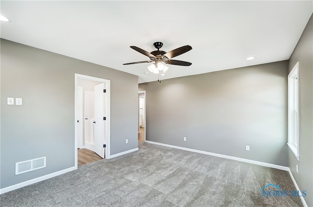 carpeted spare room with ceiling fan