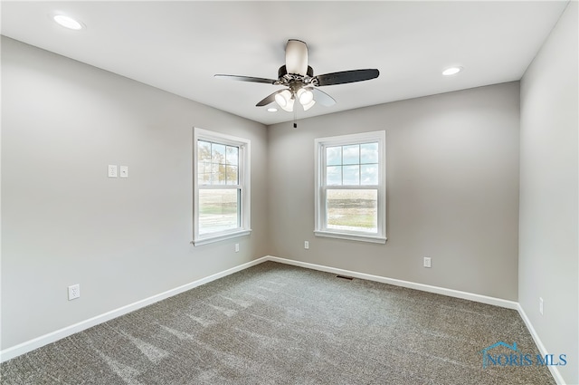 carpeted spare room featuring ceiling fan