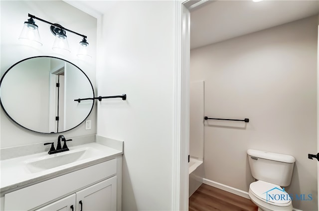 bathroom featuring wood-type flooring, vanity, and toilet